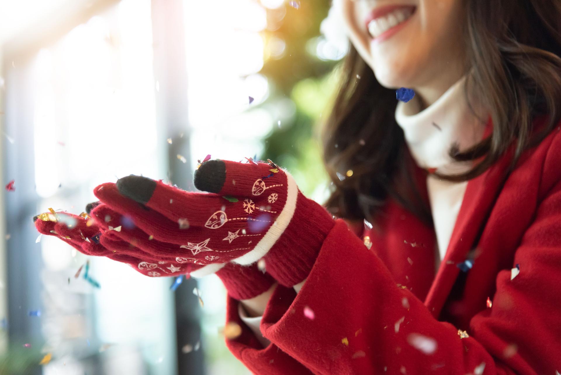 Asian girl wear red gloves celebrating with confetti falling.